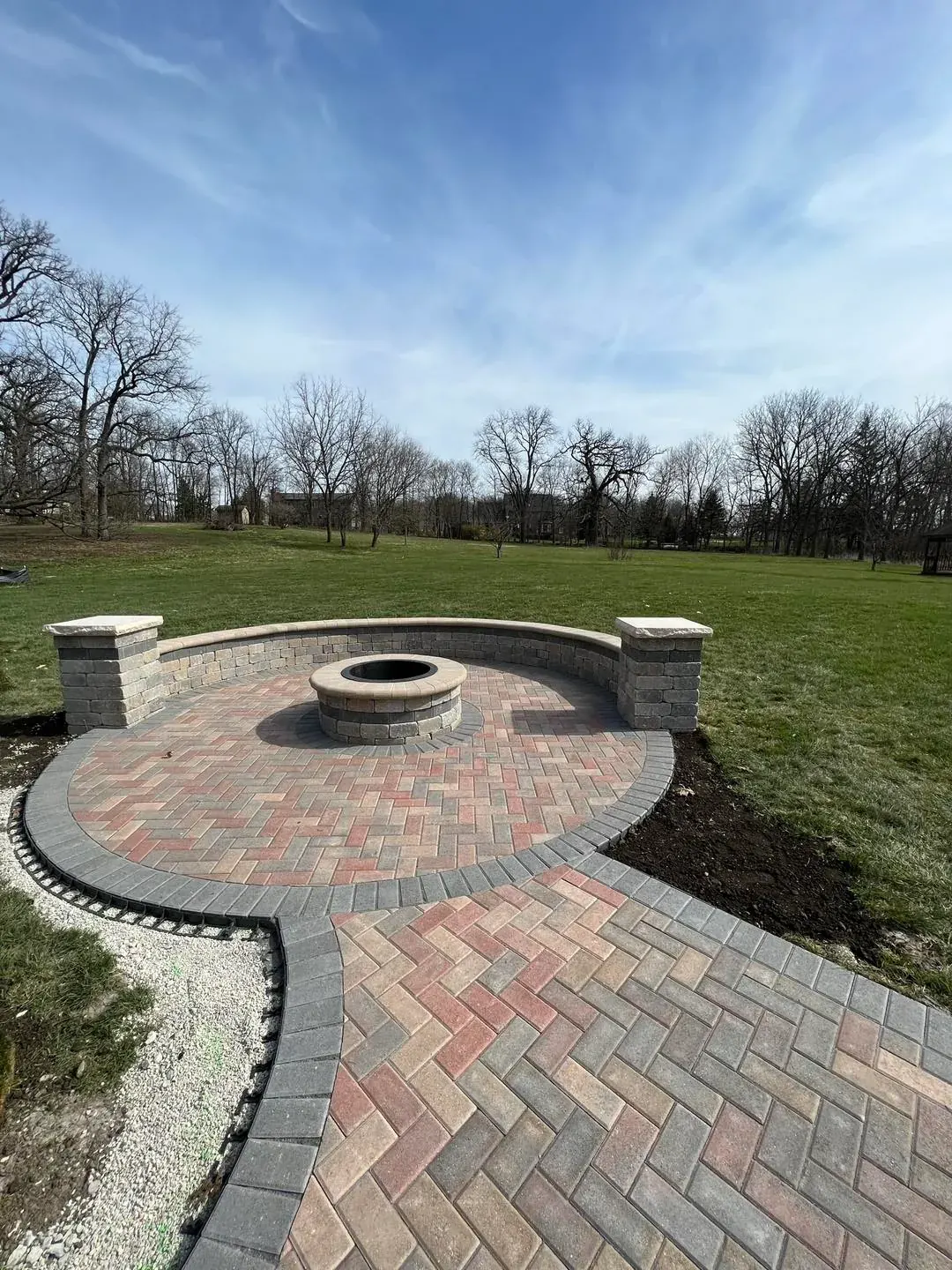 Circular herringbone paver patio with seat wall in Shorewood, Illinois